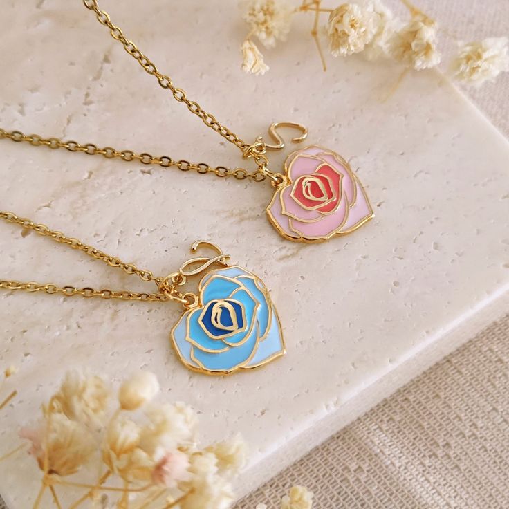 Handcrafted with the utmost care, this enamel rose heart necklace is the sweetest way to keep a feeling of love close to your heart. Perfect to be shared with your best friend, or to be given as a gift to a special person, to your mother, to your sister or why not, to your bridesmaids, the necklace can be personalized with an initial for an even more unique and special touch. The chain is in 14k gold plated stainless steel, the pendant measures 16x16mm and is in 14k gold plated brass with your c Heart-shaped Charm Necklace With Flower For Gift, Heart-shaped Flower Charm Necklace For Gift, Heart Pendant Enamel Necklace Gift, Heart Pendant Enamel Necklace For Gift, Rose Heart Necklace For Valentine's Day, Enamel Heart Pendant Necklace As Gift, Rose Heart-shaped Necklace For Gift, Enamel Heart Charm Necklace For Gifts, Valentine's Day Gift Enamel Charm Necklaces