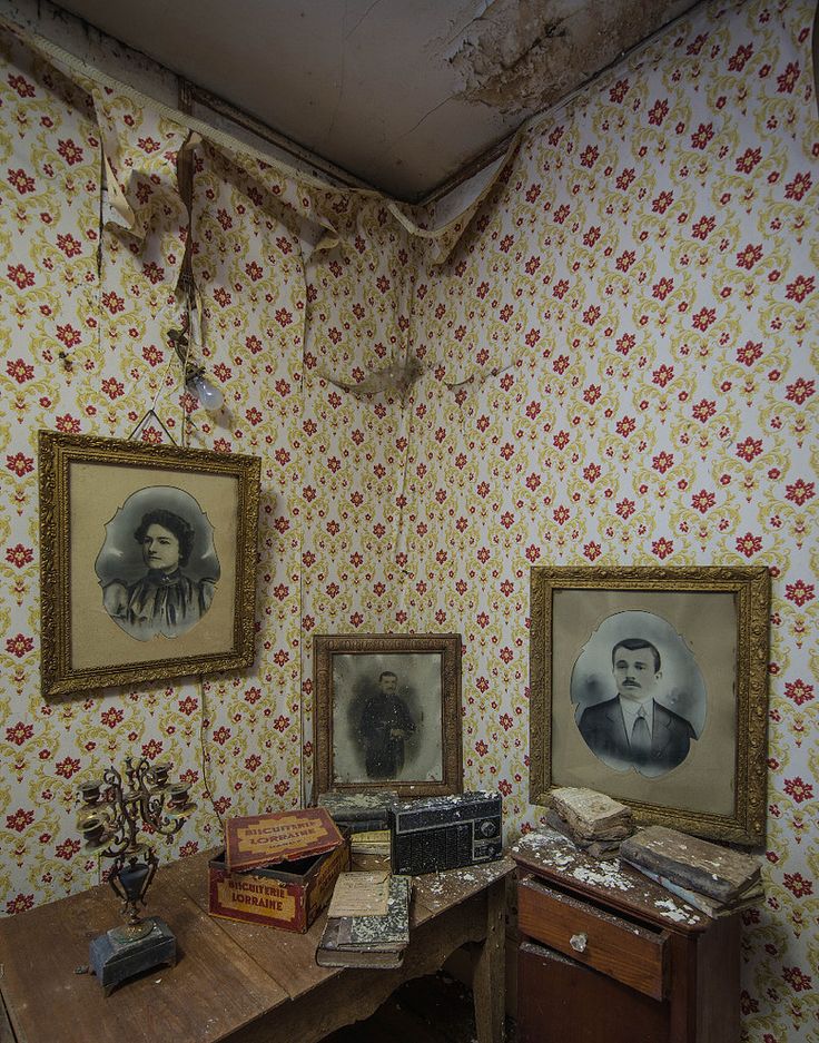 an old fashioned desk with two pictures on the wall