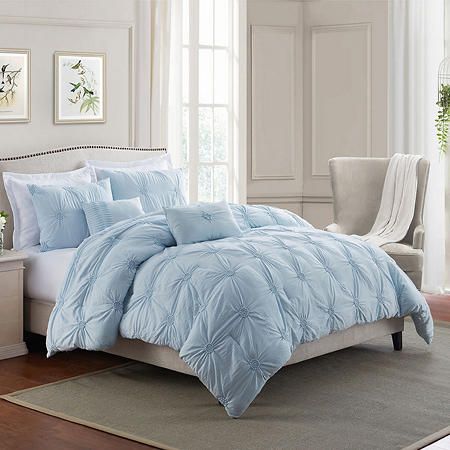 a bed with blue comforters and pillows in a room