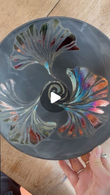 someone is holding a glass bowl with an intricate design