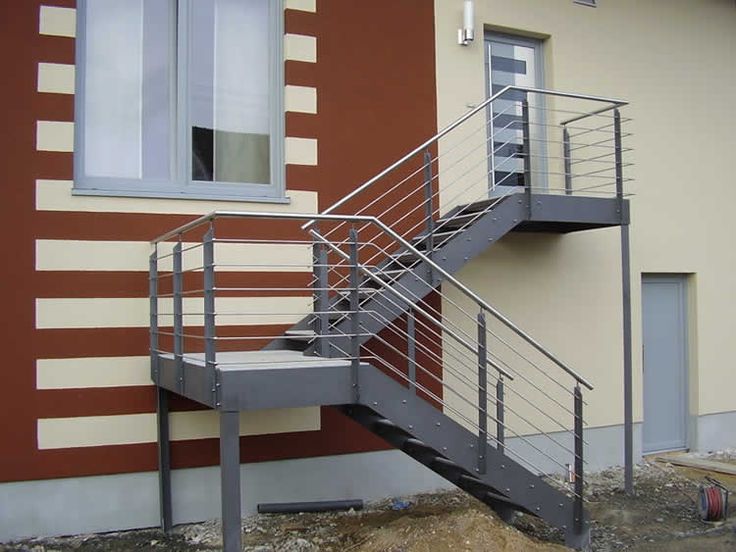 a metal stair case in front of a building