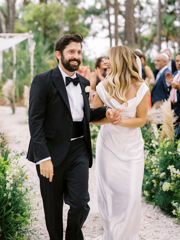 a bride and groom walking down the aisle at their outdoor wedding ceremony in charleston, ga