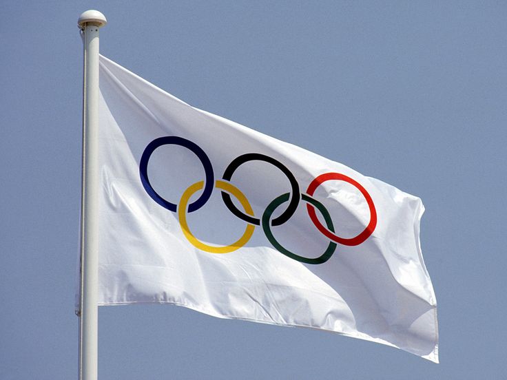 the olympic flag is flying high in the sky