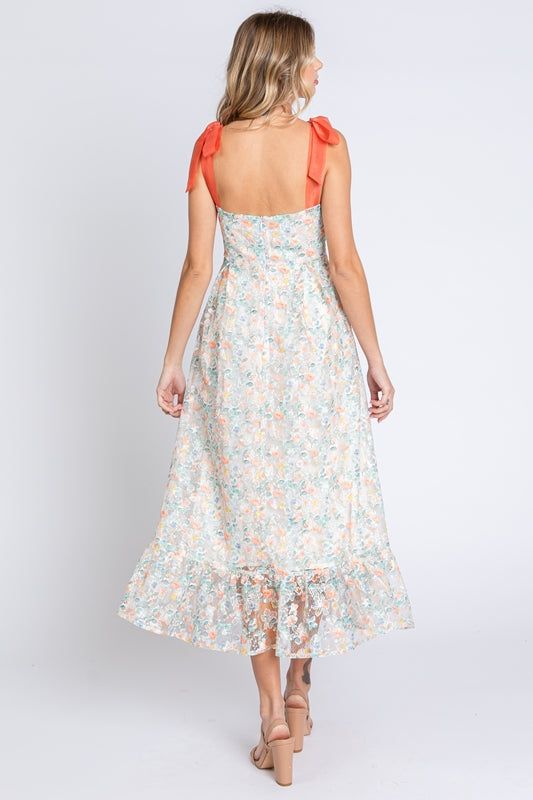 Lovelo by Gee Gee Beautiful classy embroidered sheer fabric midi dress with sweetheart neckline and self tie ribbon shoulder straps. Lined. Low back, zipper in the back. Absolutely beautiful! Color: Off White/Tangerine/Green Sizes: S-M-L Bust 32-34-36 85% Polyester, 15% Nylon, Lining 100% Rayon D1/MD50555 Sweetheart Neckline Dress With Tie Back For Brunch, Brunch Sundress With Sweetheart Neckline, Spring Sleeveless Midi Dress With Lace-up Back, Summer Midi Dress With Bow Straps, Spring Dress With Sweetheart Neckline And Tie Straps, Sleeveless Midi Dress With Lace-up Back For Spring, Knee-length Tie Back Midi Dress For Garden Party, Knee-length Midi Dress With Tie Back For Garden Party, Midi Length Dress With Lace-up Back For Brunch