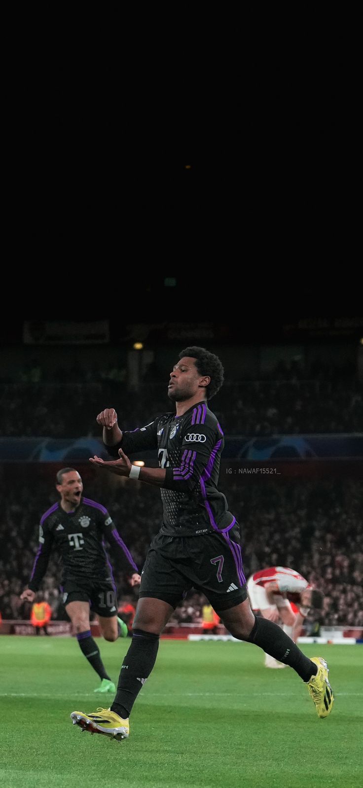 two men playing soccer on a field at night