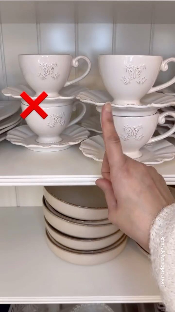 a person is pointing at dishes on the shelf