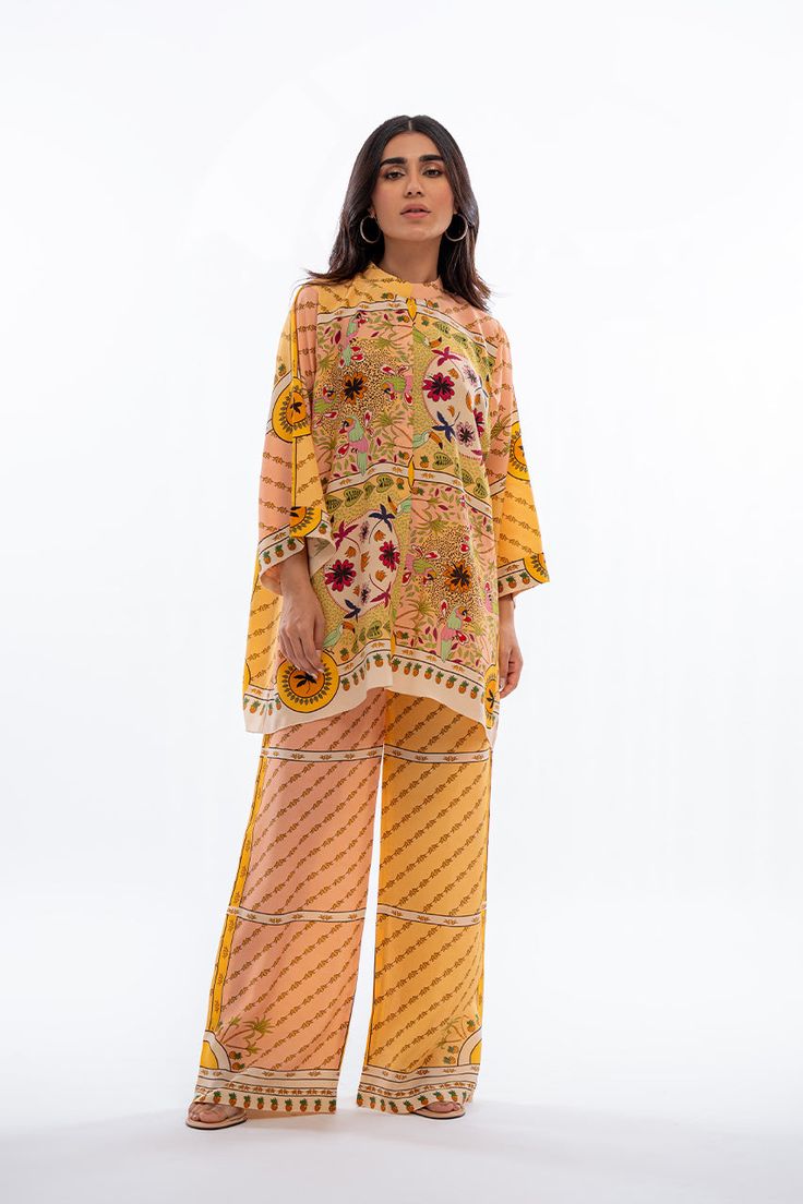 A playful fusion of colours and print takes centre stage in this mango yellow and peach co-ord set featuring a front open shirt and culottes. Yellow Straight Kurta Set With Printed Motifs, Orange Floral Print Sets For Spring, Orange Floral Print Spring Sets, Spring Floral Print Orange Sets, Spring Orange Floral Print Sets, Orange Digital Print Sets For Spring, Spring Orange Digital Print Sets, Yellow Printed Kurta For Spring, Yellow Palazzo Set With Printed Motifs For Spring