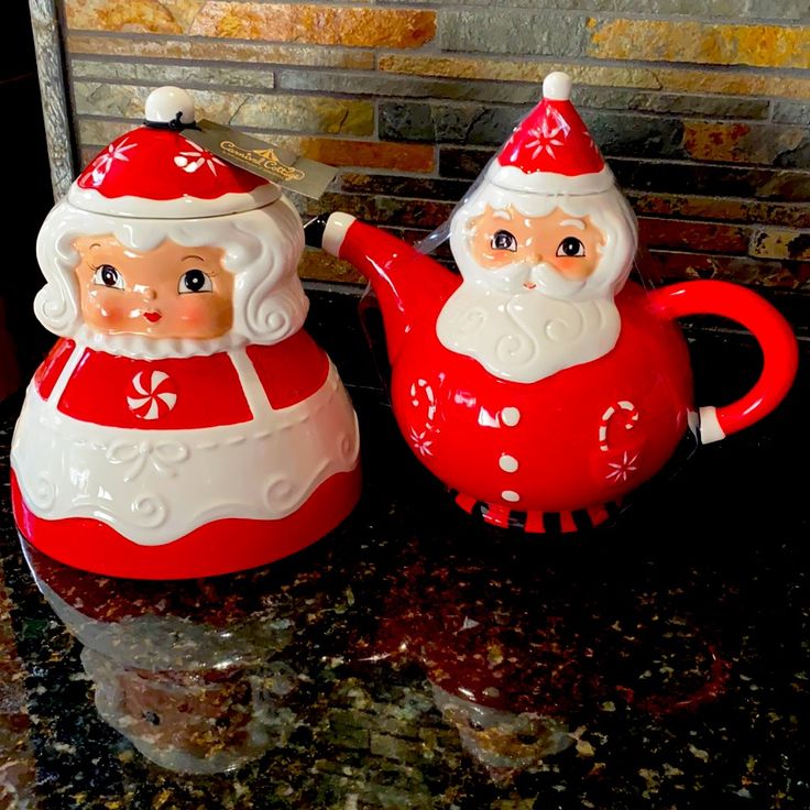 two red and white santa claus teapots sitting on a counter