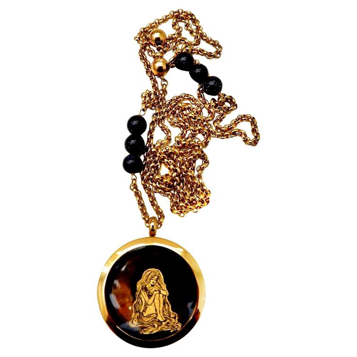 Introducing a handcrafted, one-of-a-kind necklace that combines vintage charm with artistic flair. This striking piece features a truly unique vintage locket pendant, showcasing an exquisite black onyx backing. The locket is adorned with a mesmerizing gold leaf design depicting a long-haired goddess with a giant moon and twinkling stars, capturing the essence of celestial beauty. Measuring 1.5 inches, the pendant is elegantly suspended on a vintage brass chain, which is embellished with black on Vintage Charm Medallion Necklace Styled As Amulet, Vintage Charm Medallion Necklace Amulet Style, Vintage Charm Medallion Amulet Necklace, Vintage Medallion Necklace With Amulet Style, Yellow Gold Amulet Necklace With Vintage Charm, Luxury Vintage Charm Pendant Jewelry, Black Brass Pendant Necklace, Luxury Oval Pendant Necklace For Collectors, Luxury Onyx Pendant Necklace