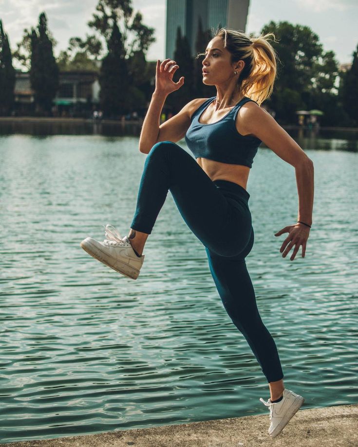 a woman is jumping in the air near water