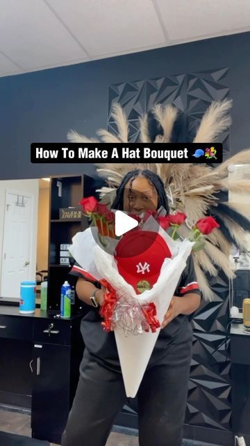 a woman standing in front of a hair salon holding flowers and wearing a black shirt