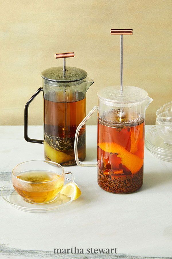 there is a cup of tea next to a pitcher