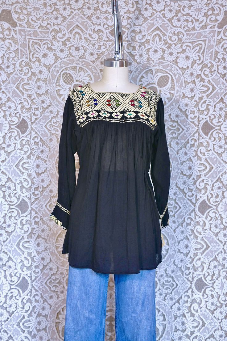 This gorgeous blouse is made from sheer black gauze cotton. It features colorful folkloric embroidery along the neckline, and loose silhouette, and tunic length. This piece is in amazing shape with no major flaws. There is no tag but it would best fit a size small to medium, see measurements for details.  All measurements taken flat across. Measurements Shoulder: 17" Bust: 21" Sleeve: 19" Length: 28" Black Cotton Blouse, Womens Blouses, Gorgeous Blouses, Weekend Sale, Cotton Blouse, Tunic Length, Cotton Blouses, Womens Clothing Tops, Black Cotton