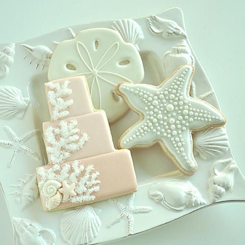 decorated cookies on a plate with shells and starfish