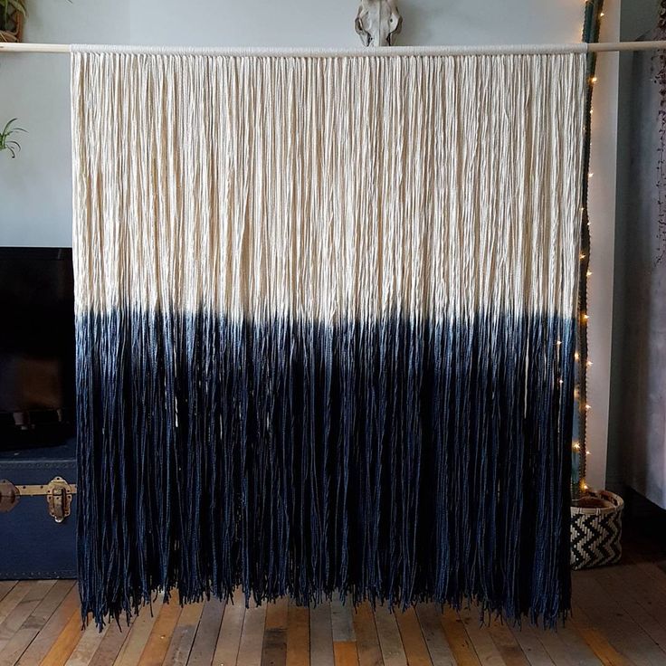 a black and white wall hanging in front of a fireplace