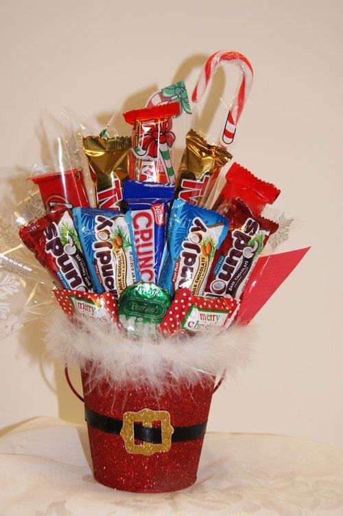 a bucket filled with candy and candies sitting on top of a table next to a white wall