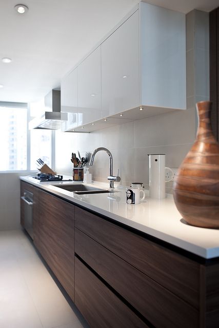 a kitchen with white counter tops and wooden cabinets