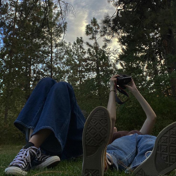 a person laying on the ground with their feet up in the air while holding a camera