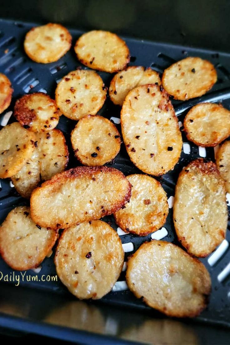 some fried food is sitting on a black tray and ready to be cooked in the oven