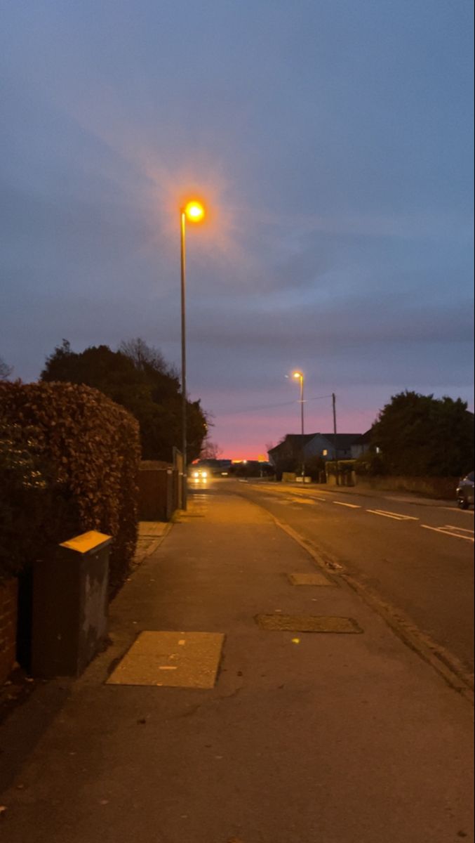 an empty street at night with no cars on the road or people in the distance