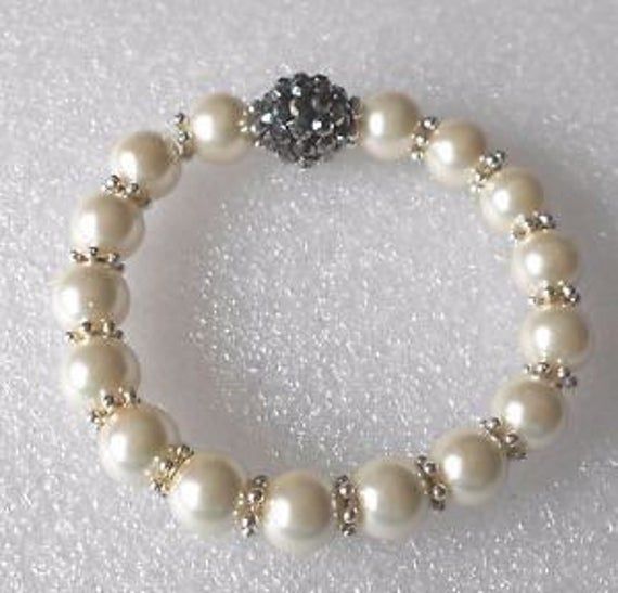 "Pretty faux pearl bracelet made with 10mm glass pearls and a disco bead. The bracelet is stretchy and comes in 2 sizes and 2 designs, and will fit up to an 8\" wrist. Do let me know if you would like a specific length of bracelet and I will do this for you. I need the measurement of your wrist.." White Pearl Stretch Bracelet For Party, Party Pearl Stretch Bracelet With Round Beads, Pearl Beaded Stretch Bracelet For Party, Beaded Pearl Stretch Bracelet For Parties, Party Pearl Beaded Stretch Bracelet, Adjustable Pearl Bracelet With Round Beads For Party, Party Pearl Beaded Bracelets With Round Beads, Pearl Beaded Bracelets For Party, Elegant 8mm Beads Stretch Bracelet For Party