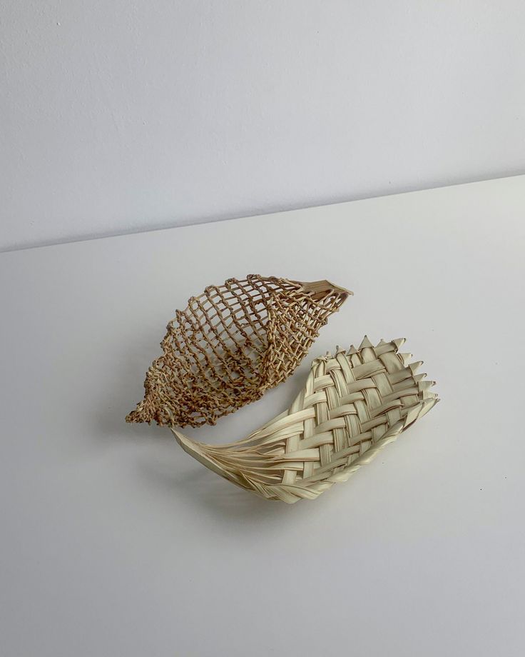 two pieces of woven material sitting on top of a white tablecloth covered countertop