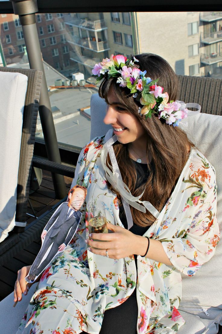 a woman sitting on top of a white couch wearing a flowered robe and holding an umbrella