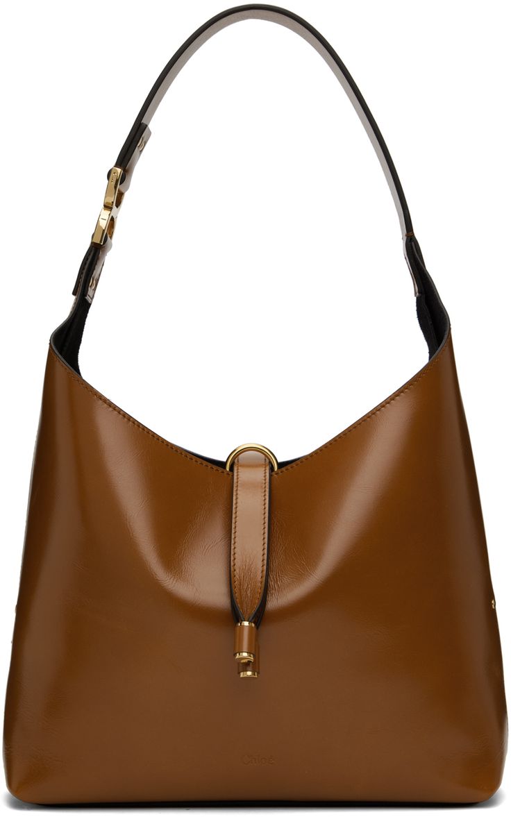 LWG-certified crackled calfskin tote in tan. · Studs throughout · Logo hardware at integrated shoulder strap · Logo embossed at face · Tab-slot closure · Zip pocket at suede interior · Logo-engraved gold-tone hardware · H8.5 x W10.5 x D3 · Total height: H18 Supplier color: Clay brown Cognac Leather Shoulder Bag With Metal Hardware, Brown Calf Leather Hobo Bag For Business, Business Brown Calf Leather Hobo Bag, Brown Shoulder Bag With Metal Hardware For Work, Cognac Calf Leather Shoulder Bag With Gold-tone Hardware, Cognac Shoulder Bag With Metal Hardware For Business, Cognac Shoulder Bag With Palladium Hardware For Work, Modern Brown Shoulder Bag With Metal Hardware, Formal Cognac Shoulder Bag With Silver-tone Hardware