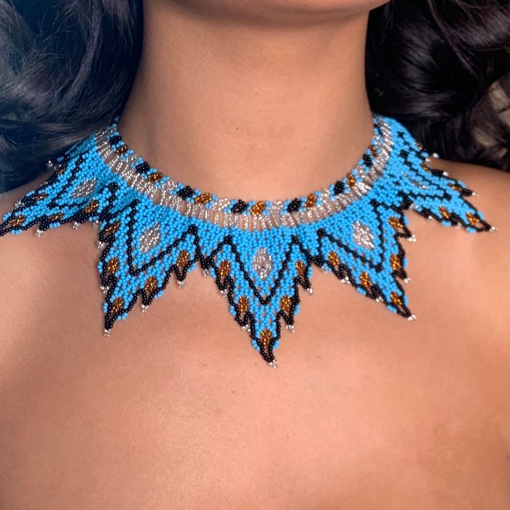 a woman wearing a blue and brown beaded necklace with matching earrings on her neck