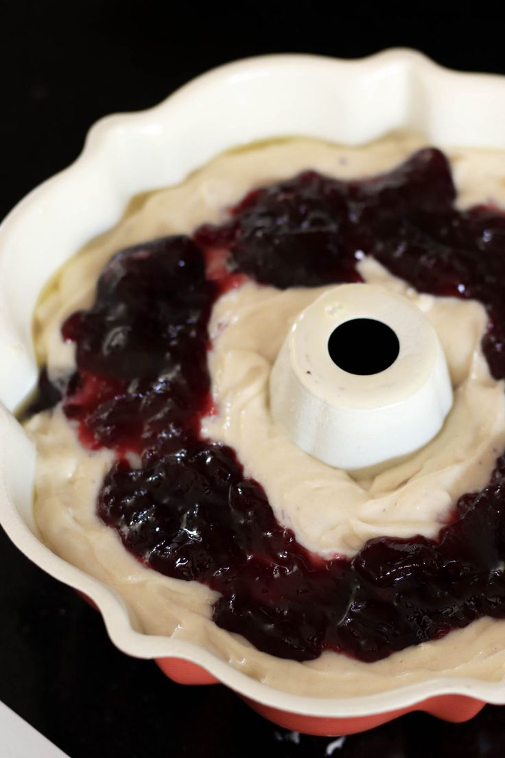 a blueberry pie in a white bowl on top of a stove