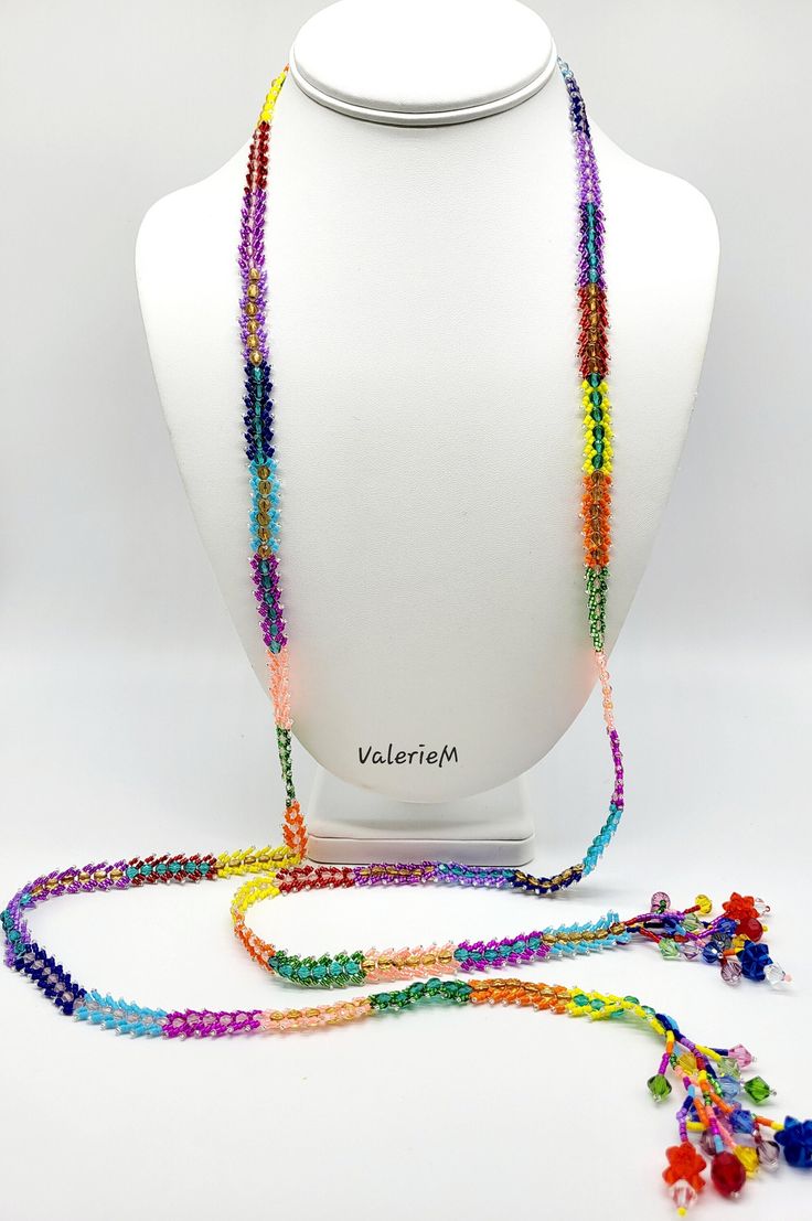 a white mannequin with multicolored beads and a necklace on it's neck