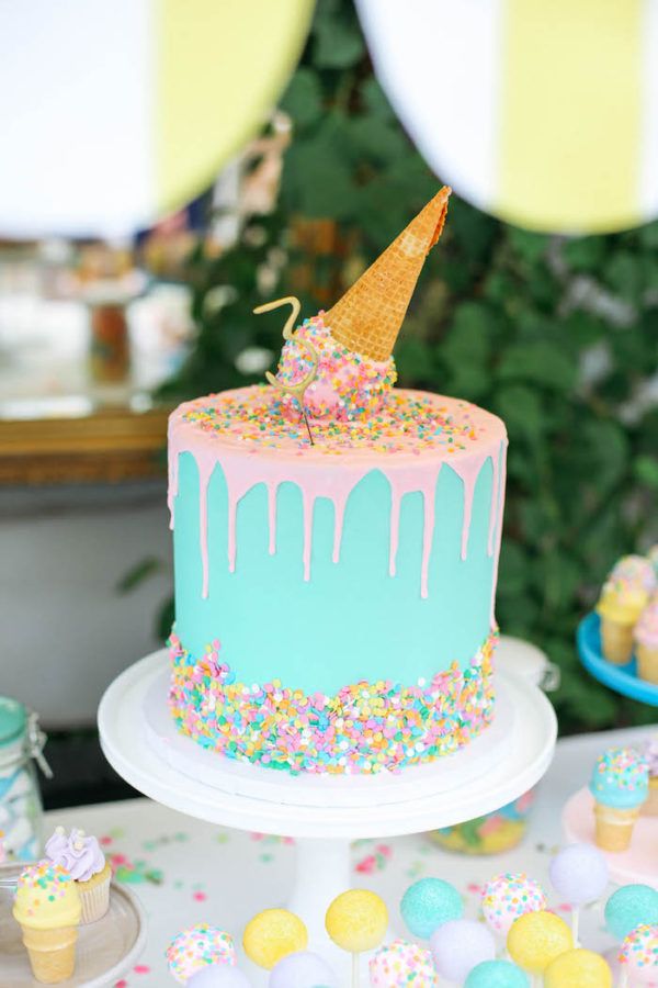 a birthday cake decorated with sprinkles and an ice cream cone on top