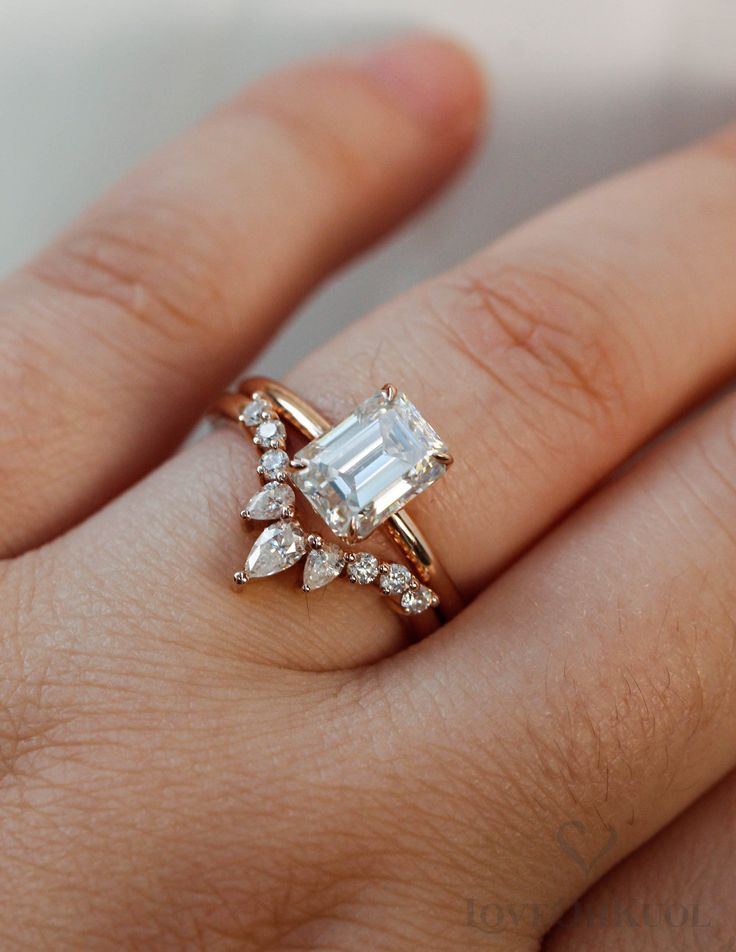 a woman's hand with an engagement ring on top of her finger and diamond band