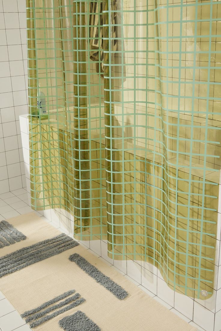 a bathroom with yellow shower curtains and rugs