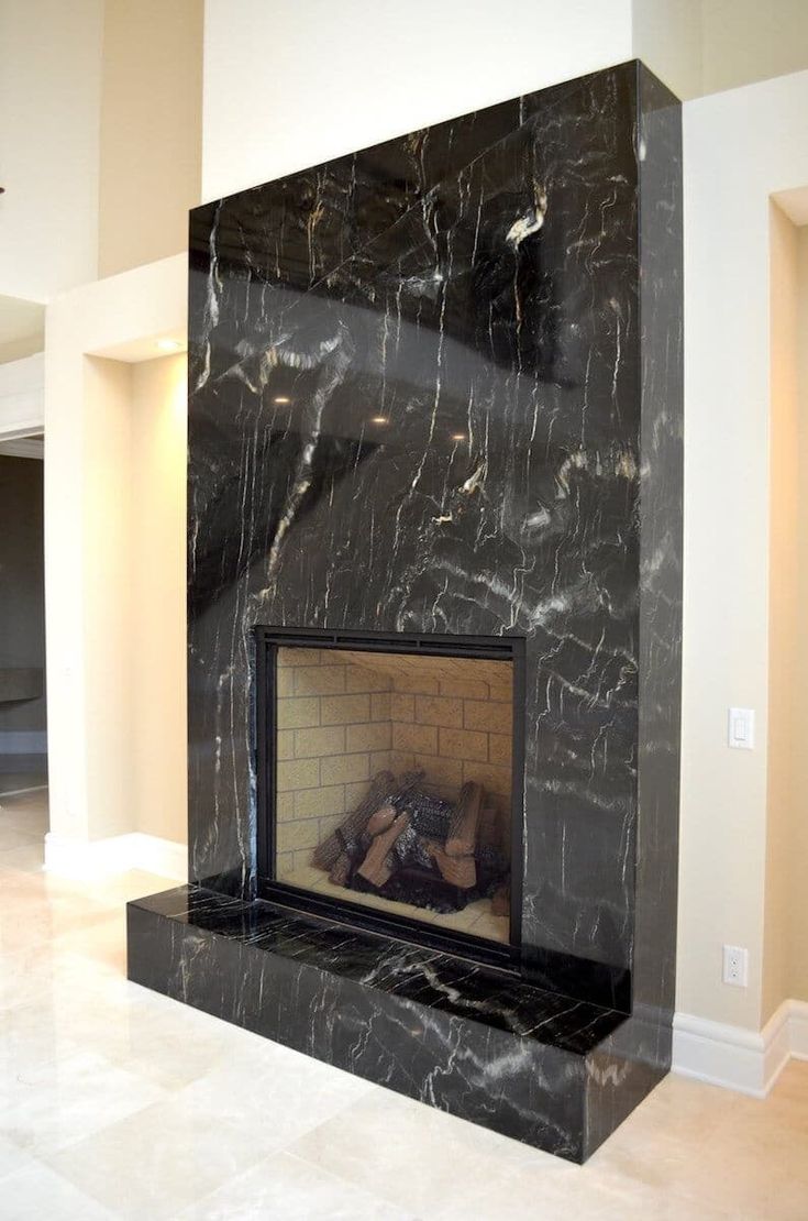 a large fireplace with a black marble surround