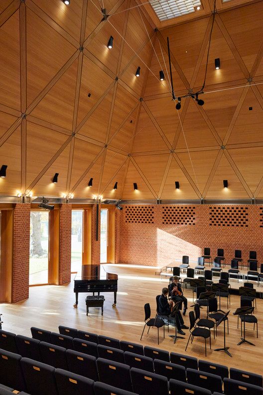 an empty concert hall with rows of chairs and piano