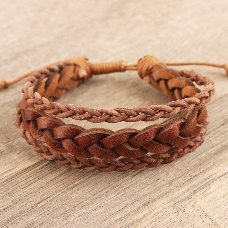 Designed for both men and women, Deepika Lohani's wristband bracelet is a shining example of Indian leathercraft. Indian artisans hand braid three strips of leather to create the bracelet, joining the braids with a waxed cotton cord. Pull the cord tight against your wrist with the sliding knot closure for a close fit. Brown Leather Bracelet Fashion Accessory, Handmade Leather Friendship Bracelets, Handmade Leather Braided Bracelet, Brown Leather Strap Braided Bracelet Gift, Leather Braided Bracelet Gift, Gift Braided Leather Bracelet, Handmade Leather Braided Bracelets, Adjustable, Handmade Adjustable Leather Braided Bracelets, Brown Leather Braided Bracelet As Gift