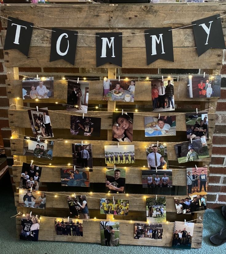 a wooden pallet with pictures on it and lights strung from the top to make a family photo display