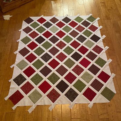 a large piece of quilt sitting on top of a wooden floor next to a dresser