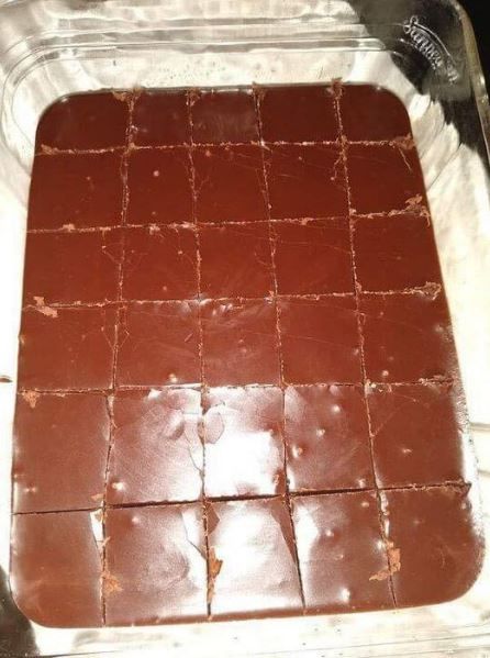 chocolate squares in a baking dish with brown icing on the top and bottom, ready to be baked