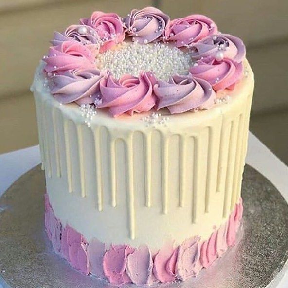 the cake is decorated with pink and white icing