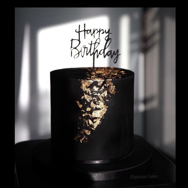 a black and gold birthday cake with the words happy birthday on it's top