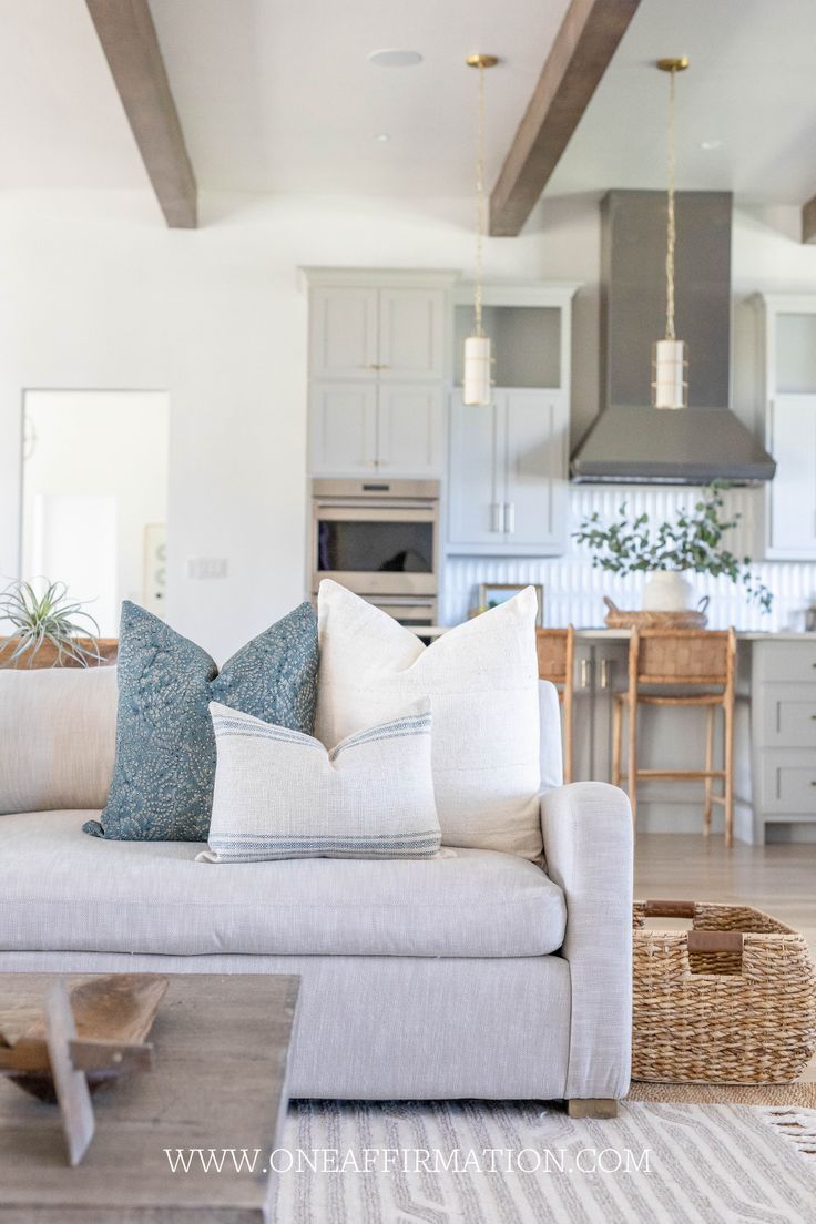 a living room filled with lots of furniture and pillows on top of a white couch