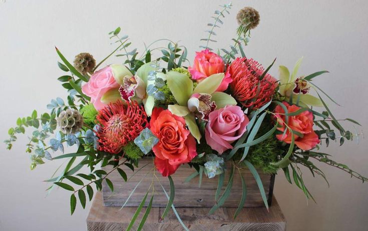 an arrangement of flowers in a wooden box