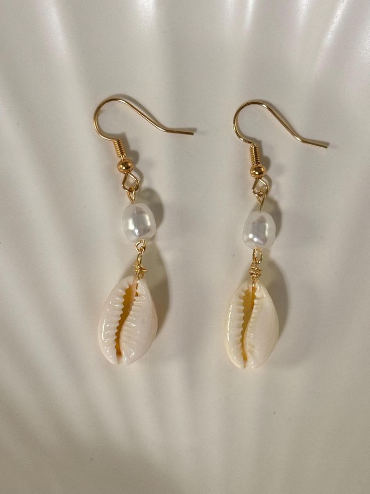 - Gold plated ✨ - Lead and nickel free 🤍 - Real cowrie seashell 🐚 - Each seashell is unique and straight from the ocean/beach 🏝️ - Please note that sometimes seashells have impurities -- they are imperfectly perfect 💖 Cheap Beige Earrings For Beach, Cheap Shell Drop Earrings, White Bohemian Dangle Shell, Bohemian White Dangle Shell, Pearl Drop Shell Earrings, Beach Jewelry For Pierced Ears, Shell-shaped, Dangle Shell Earrings With Pearl Drop, White Shell Dangle Jewelry, Summer Shell Dangle Jewelry