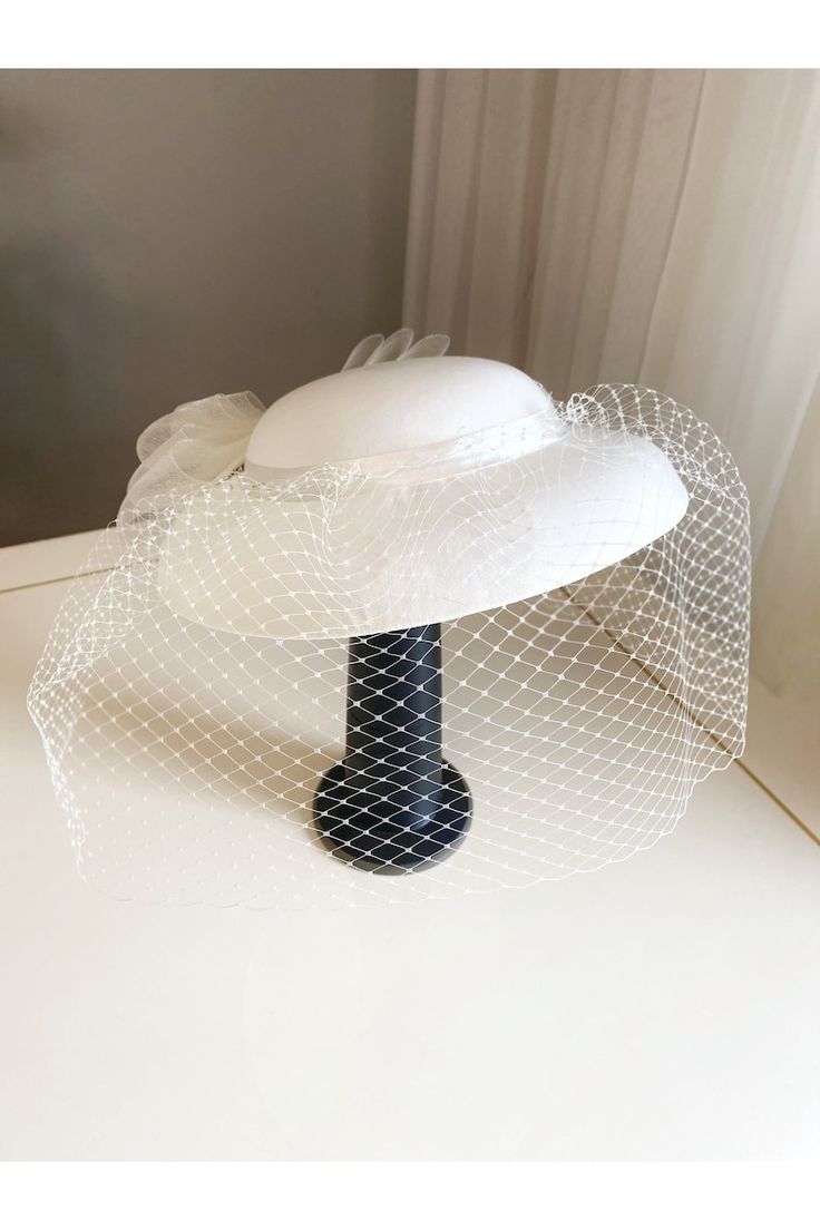 a white hat with netting on it sitting on top of a table