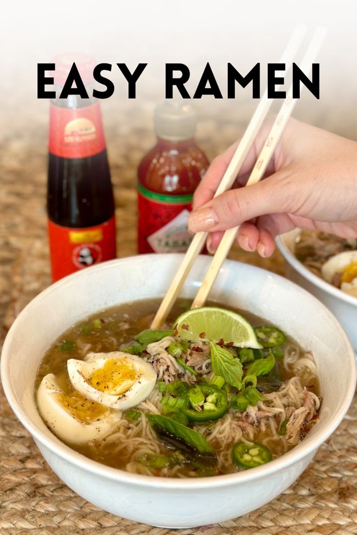 someone holding chopsticks over a bowl of ramen with an egg in it