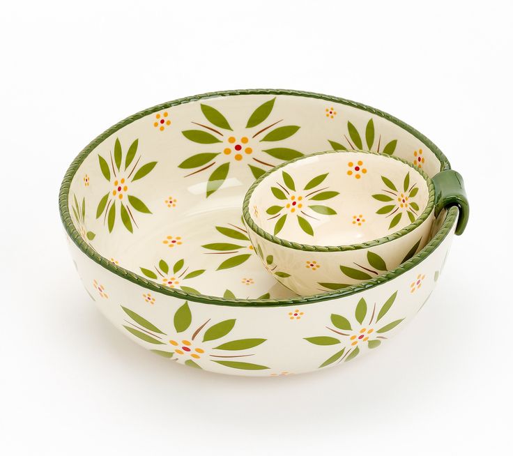 two white bowls with green handles and floral designs on the rims are sitting side by side