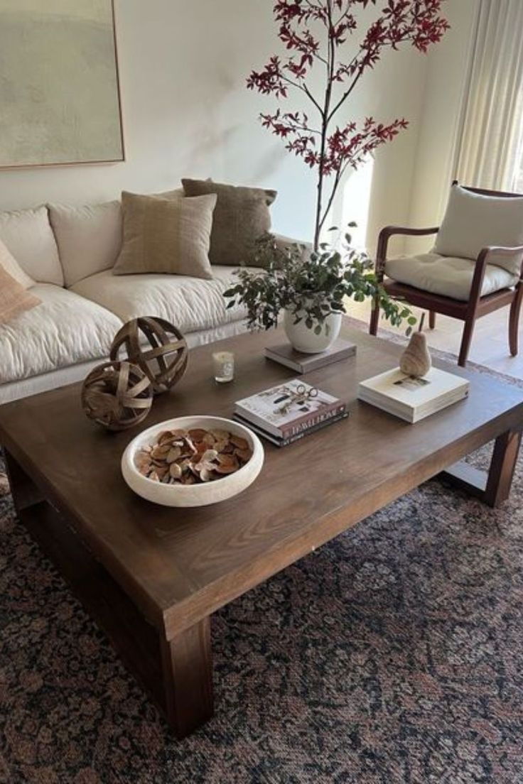 a living room filled with furniture and a tree in the middle of the room on top of a coffee table