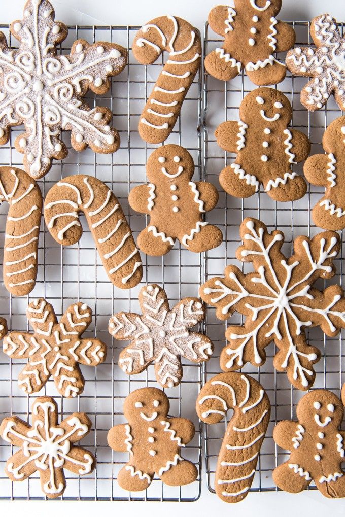 a cooling rack filled with lots of different kinds of gingerbreads on top of a white table